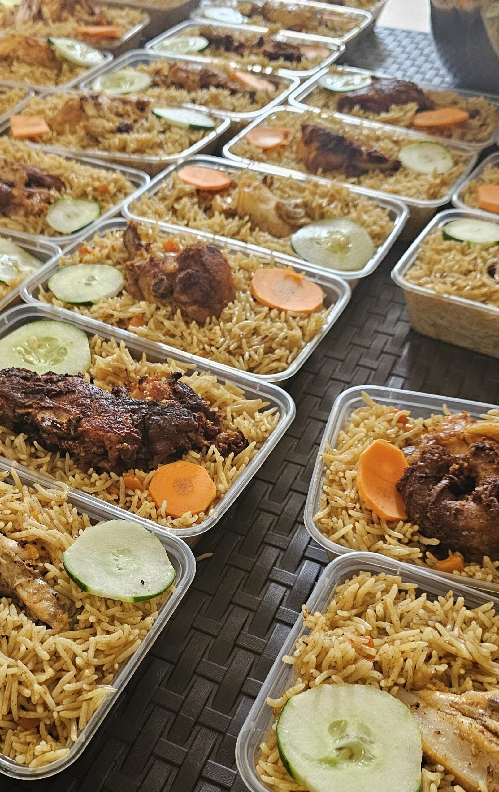 Trays of golden biryani rice with sliced vegetables and savory meats.